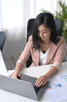 Above view asian woman office worker using computer laptop at her workplace.