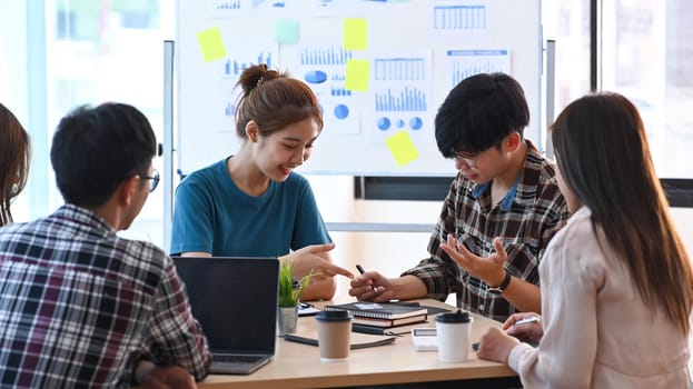 Group of young business people brainstorming and discussing ideas of the new startup project together at modern office.