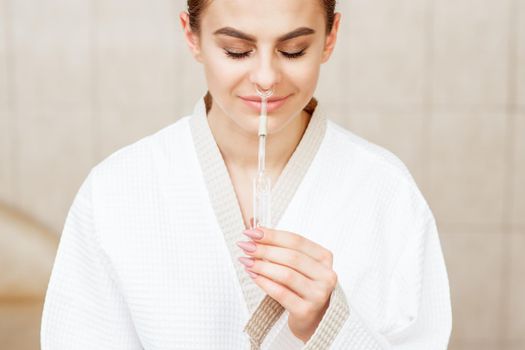 Woman receives nasal inhalation Maholda by essential oil in nose at spa.