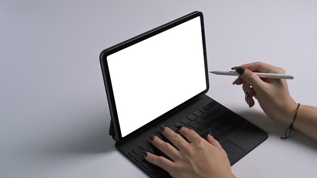 Cropped shot woman holding stylus pen pointing on digital tablet screen.