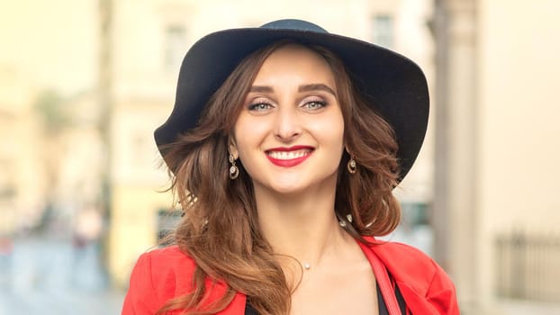Close up portrait of fashionable young pretty girl wearing hat posing at the city in Europe.