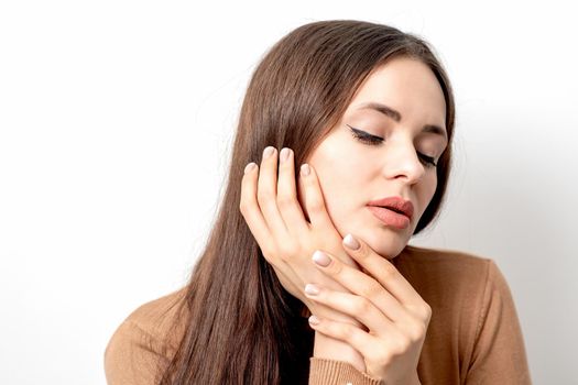 Portrait of beautiful woman with makeup and beige manicure on white background. Sexy sensual beauty woman.