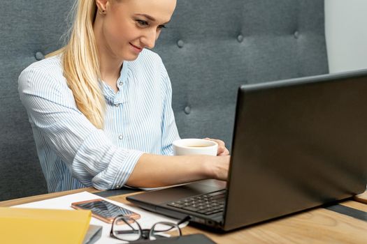 Young woman is using laptop during online learning at home office.