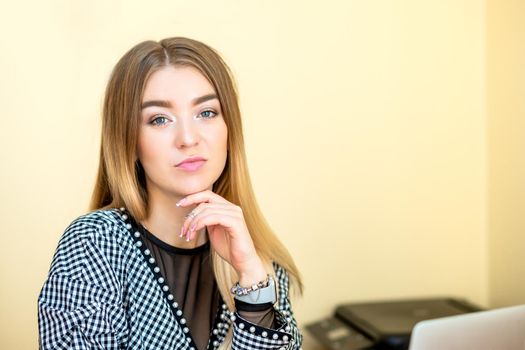 Portrait of a casual business woman sitting at her workplace in home office.