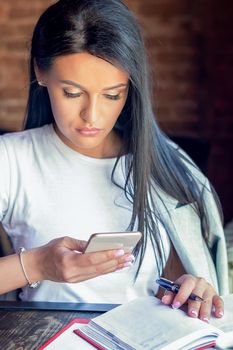 Closeup image of an businesswoman is holding, using and looking at smart phone cafe. Business concept.