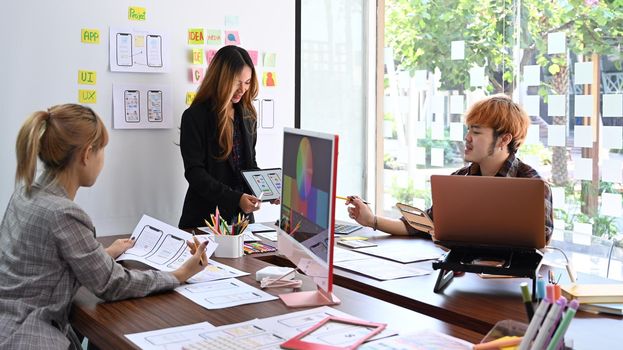 Group of web developer is brainstorming and planning sketch, prototype, framework, layout future app design project together.