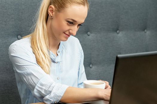 Young woman is using laptop during online learning at home office.