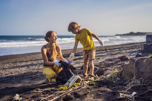 Mother and son are cleaning up the beach. Natural education of children.
