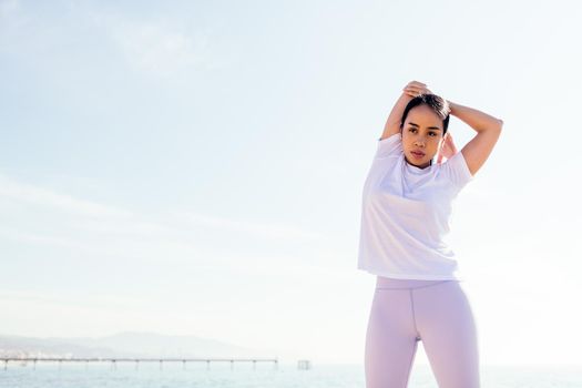 young asian sportswoman stretching arm outdoors, concept of sport and active lifestyle