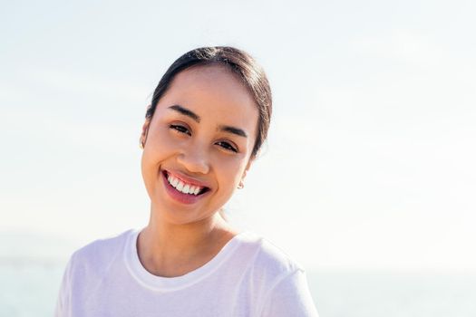 happy young asian woman smiles looking at camera, concept of happiness and purity