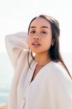 vertical portrait of a young asian woman looking with sensual expression, concept of beauty and purity