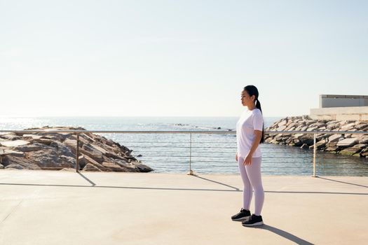 young sports woman concentrating on standing during outdoor training, concept of sport and active lifestyle