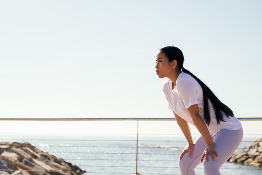 young sports woman tired from effort rests to catch her breath, concept of sport and active lifestyle