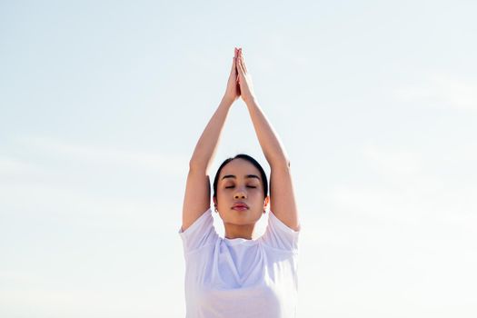 portrait of a young asian woman relaxing while practicing yoga with her eyes closed, concept of spirituality and relax