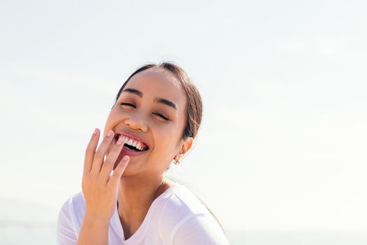 young asian woman laughing with her hand in her mouth, concept of happiness and purity