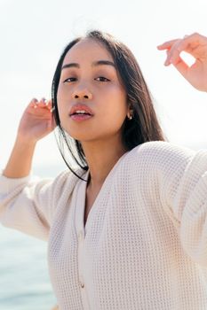 young asian woman dressed in white dances free and carefree, concept of beauty and purity