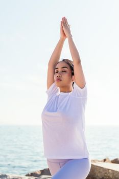 young asian woman meditating practicing yoga with her eyes closed, concept of spirituality and relax