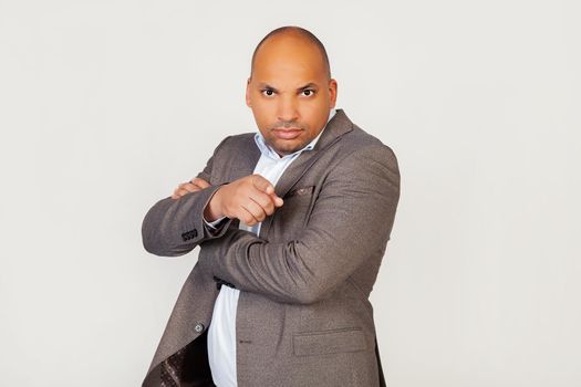 Young male African American businessman, looking angrily and frowning at the camera, points with his forefinger, as if accusing or accusing you of a mistake. as if choosing you