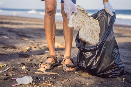 Young man cleaning up the beach. Natural education of children.