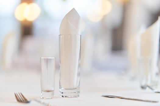 Glass with a glass on the festive table. Festive table setting.