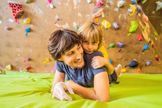 Dad and son at the climbing wall. Family sport, healthy lifestyle, happy family.