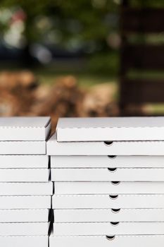 Stack of white cardboard pizza packages. Pizza packages close-up. High-quality photo