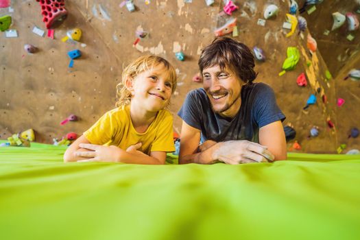 Dad and son at the climbing wall. Family sport, healthy lifestyle, happy family.