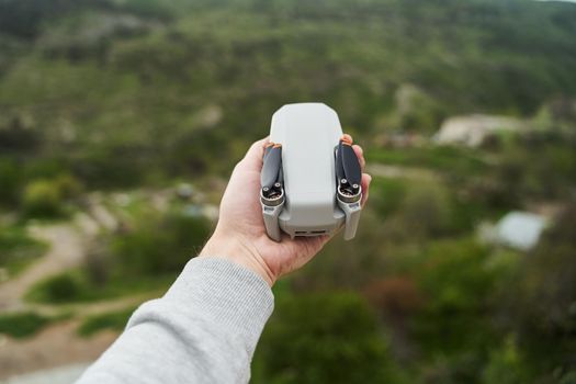 Modern small compact quadcopter in a man's hand. Launching a drone from your hand. High quality photo