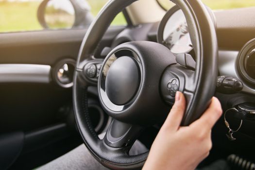 Young girl holding a steering wheel. A girl drives a car.