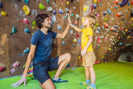 Dad and son at the climbing wall. Family sport, healthy lifestyle, happy family.