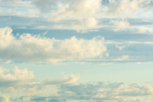 White airy clouds in yellow sunset light.