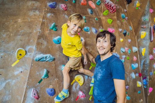 Dad and son at the climbing wall. Family sport, healthy lifestyle, happy family.