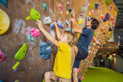 Dad and son at the climbing wall. Family sport, healthy lifestyle, happy family.