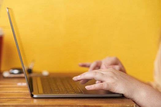 Girl is typing text on the keyboard. Close-up. Work from home. Remote work.