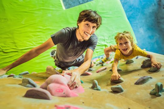 Dad and son at the climbing wall. Family sport, healthy lifestyle, happy family.