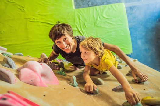 Dad and son at the climbing wall. Family sport, healthy lifestyle, happy family.