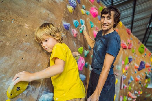 Dad and son at the climbing wall. Family sport, healthy lifestyle, happy family.