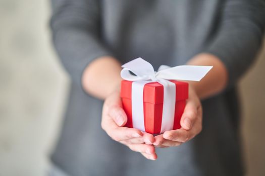 Woman holding small red present box in hands. High-quality photo