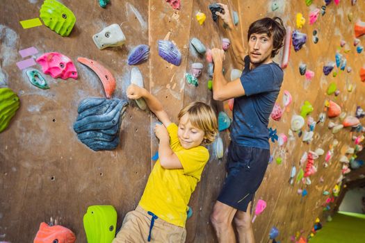 Dad and son at the climbing wall. Family sport, healthy lifestyle, happy family.