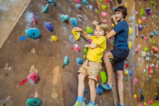 Dad and son at the climbing wall. Family sport, healthy lifestyle, happy family.