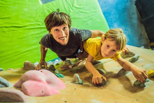 Dad and son at the climbing wall. Family sport, healthy lifestyle, happy family.