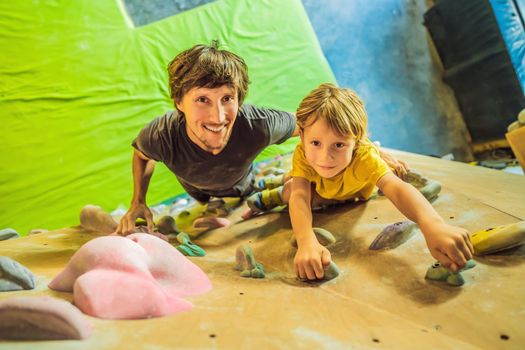 Dad and son at the climbing wall. Family sport, healthy lifestyle, happy family.