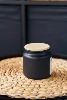 Stylish black jar with a wooden lid for a candle or cream. High quality photo