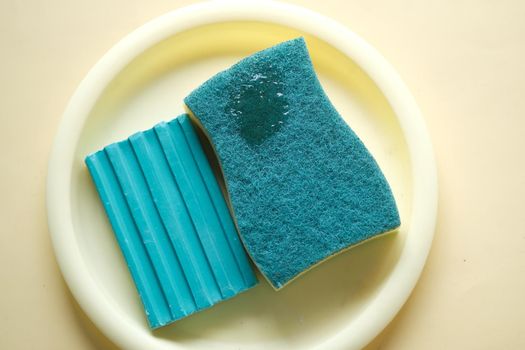 sponge , plate and soap bar on yellow ,
