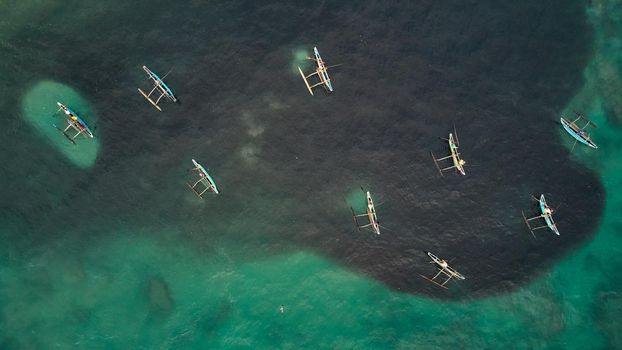 Aerial view of boats of fishermen fishing in the ocean. Schools of fish in the ocean view from above