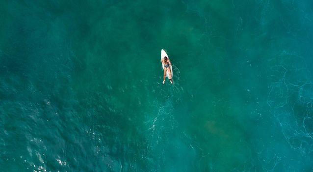 Aerial view of the ocean and surfer girl. Surfing in Midigama. Sri Lanka