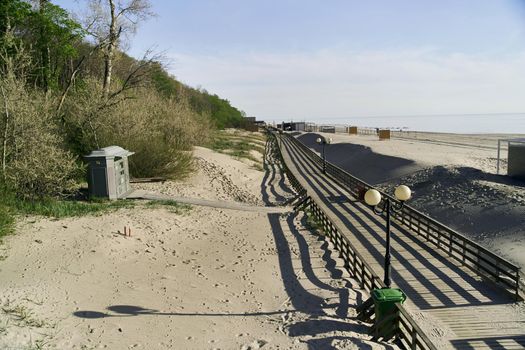 Wooden Boardwalk on Yantarniy Beach. Beach with a blue flag. Kaliningrad region. High-quality photo