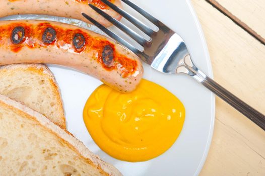 traditional fresh German wurstel sausages grilled with yellow mustard 