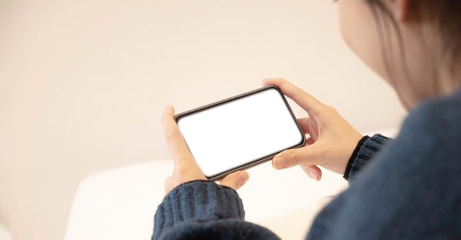 Top view of woman hands holding smart phone with blank copy space screen for your text message or information content..