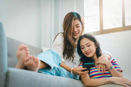 lgbtq, lgbt concept, homosexuality, portrait of two asian women enjoying together and showing love for each other while using smartphone mobile to take selfies.